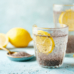 Glass of refreshing chia seed water with slices of lemon and lime and a straw.