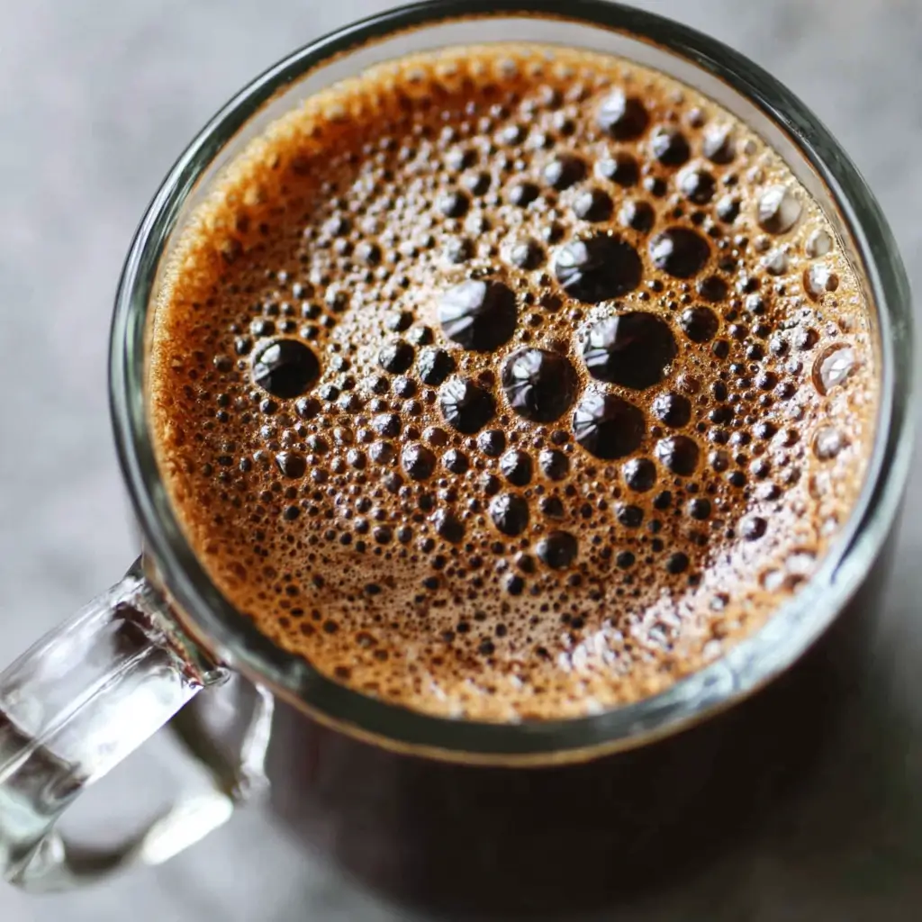 Close-up of a perfectly smooth and blended bariatric seed coffee in a glass mug, showing a clump-free texture.
